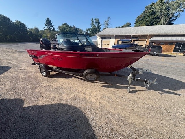 Red Speedboat with outboard motor, trailer, and windshield at Camp & Cruise.