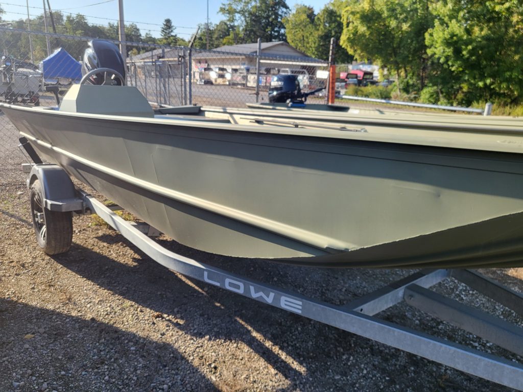 Aluminum fishing boat on trailer at Camp & Cruise, perfect for boating and water sports enthusiasts.