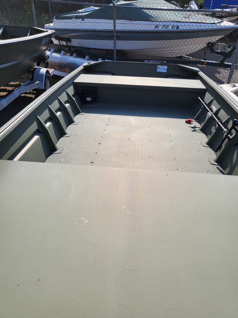 Boat dock showcasing boats and trailers at Camp & Cruise dealership.