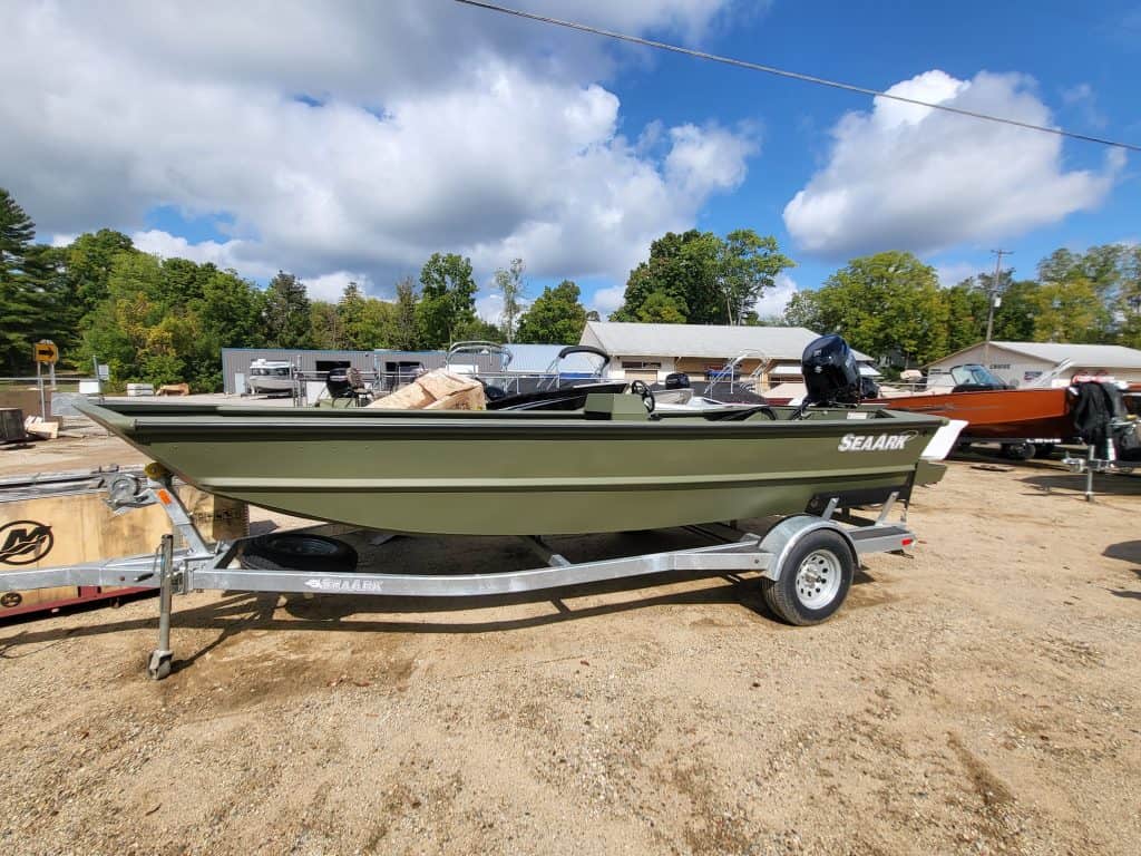 Boat on trailer at Camp & Cruise dealership in an outdoor lot.