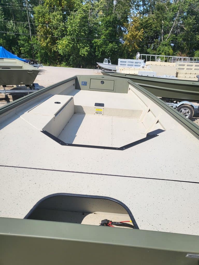 Aluminum boat interior with storage compartments and clean deck area.