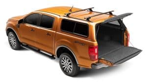 Orange pickup truck with open bed and sleek design, perfect for sports equipment and outdoor activities.