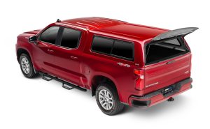 Red Chevrolet Silverado pickup truck with open bed cover, showcasing vehicle accessories and outdoor gear for sale.