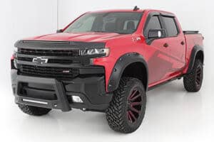 Red Chevrolet pickup truck with off-road tires, rugged design, and modern features.