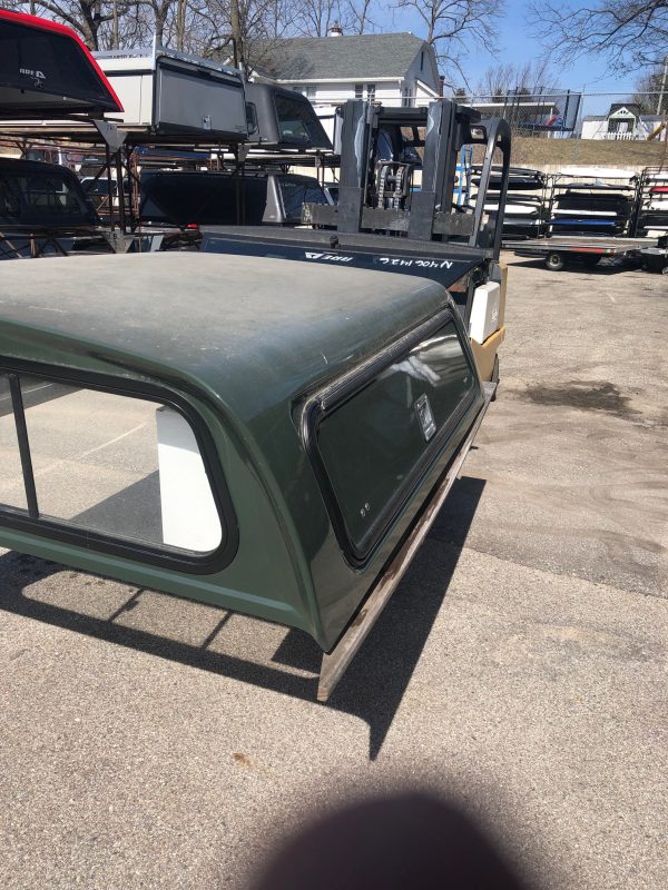 Durable green truck bed with black window frame, ideal for sports and outdoor use at Camp & Cruise.