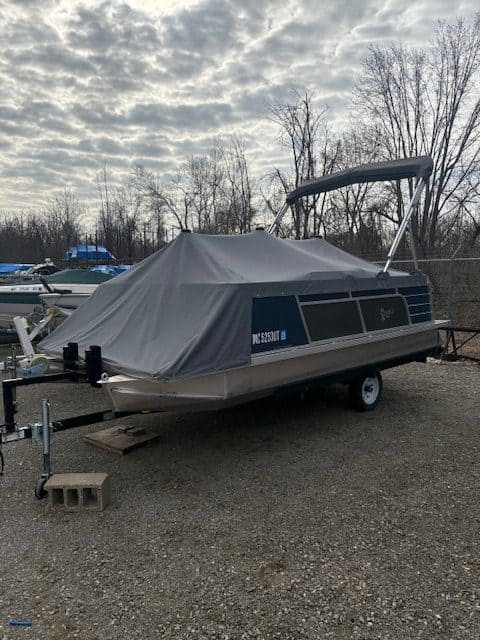 Pontoon boat covered with a protective tarp at Hall's Sport Center.